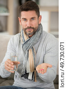 sick man with glass of water and pills. Стоковое фото, агентство Ingram Publishing / Фотобанк Лори