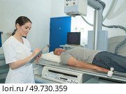 female professional taking xray of male patient. Стоковое фото, агентство Ingram Publishing / Фотобанк Лори