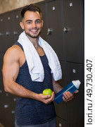 portrait of sportsman holding water and apple in locker room. Стоковое фото, агентство Ingram Publishing / Фотобанк Лори