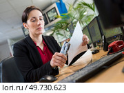 woman stapling papers with stapler. Стоковое фото, агентство Ingram Publishing / Фотобанк Лори