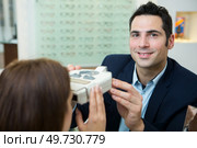 happy optician examining patients eyes. Стоковое фото, агентство Ingram Publishing / Фотобанк Лори