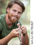 skillful man whittling stick in forest. Стоковое фото, агентство Ingram Publishing / Фотобанк Лори