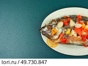 Delicious fried tilapia fish with fruit sauce in white plate. Flat lay with copy space.. Roasted yummy whole tilapia, Vietnamese food. Стоковое фото, агентство Ingram Publishing / Фотобанк Лори