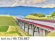Autostrada highway in Europe. D1 magistal near Spissky hrad, arched bridge. Motorway viaduct bridge, Spis region, Slovakia. Green summer fields, hills of Tatra mountains. Travel in vacations. Стоковое фото, агентство Ingram Publishing / Фотобанк Лори