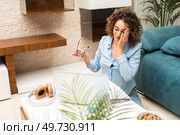 Tired young female freelancer in formal clothes having headache while working on laptop at table in living room at home. Exhausted woman with laptop in living room at home. Стоковое фото, агентство Ingram Publishing / Фотобанк Лори