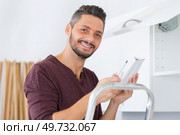 serviceman in overall working on cupboard. Стоковое фото, агентство Ingram Publishing / Фотобанк Лори
