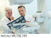 two yound doctors examining a x-ray film at the diaphanoscope. Стоковое фото, агентство Ingram Publishing / Фотобанк Лори