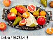 Apples, pears, mangoes and citrus fruits on a stylish tray.. Assortment of fruits on a vintage tray. Стоковое фото, агентство Ingram Publishing / Фотобанк Лори