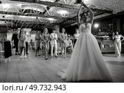 bride in a white dress throws a wedding bouquet to her unmarried girlfriends. Стоковое фото, агентство Ingram Publishing / Фотобанк Лори