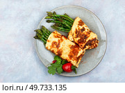 Egg omelet with asparagus and greens on grey background. Freshly made omelette with asparagus. Стоковое фото, агентство Ingram Publishing / Фотобанк Лори