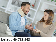 Woman passing medication to injured man. Стоковое фото, агентство Ingram Publishing / Фотобанк Лори