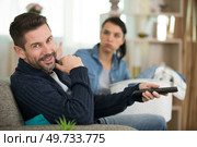 happy man and bored woman watching tv. Стоковое фото, агентство Ingram Publishing / Фотобанк Лори