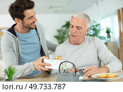 mature son congratulating elderly father giving him birthday gift. Стоковое фото, агентство Ingram Publishing / Фотобанк Лори