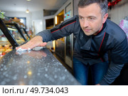a baker cleaning his showcase. Стоковое фото, агентство Ingram Publishing / Фотобанк Лори