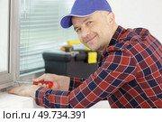 worker fasten the handle to a plastic window. Стоковое фото, агентство Ingram Publishing / Фотобанк Лори