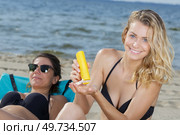 woman holding sunscreen on the beach. Стоковое фото, агентство Ingram Publishing / Фотобанк Лори