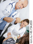 senior doctor injecting patient with syringe to collect blood. Стоковое фото, агентство Ingram Publishing / Фотобанк Лори