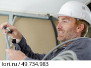 close view of tradesman cutting electricity cable. Стоковое фото, агентство Ingram Publishing / Фотобанк Лори
