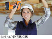 young woman with toolbelt using drill. Стоковое фото, агентство Ingram Publishing / Фотобанк Лори