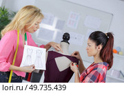 women dressmaking and following sketched design. Стоковое фото, агентство Ingram Publishing / Фотобанк Лори