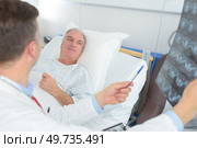 doctor examining patients xray in hospital room. Стоковое фото, агентство Ingram Publishing / Фотобанк Лори