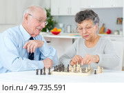 elderly couple at home playing chess. Стоковое фото, агентство Ingram Publishing / Фотобанк Лори