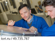 man explaining equipment to trainee. Стоковое фото, агентство Ingram Publishing / Фотобанк Лори