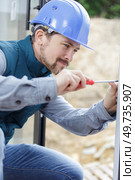 man screwing and repairing door handle. Стоковое фото, агентство Ingram Publishing / Фотобанк Лори