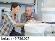 friendly couple choosing paint can in household store. Стоковое фото, агентство Ingram Publishing / Фотобанк Лори
