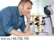 man trying to understand how to use coffee machine. Стоковое фото, агентство Ingram Publishing / Фотобанк Лори