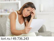 woman in casual clothes looking with confusion a letter. Стоковое фото, агентство Ingram Publishing / Фотобанк Лори