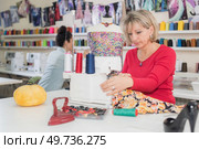 smiley woman sewing on sewing-machine. Стоковое фото, агентство Ingram Publishing / Фотобанк Лори