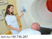 Nurse talking to patient entering scanner. Стоковое фото, агентство Ingram Publishing / Фотобанк Лори