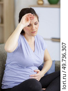 young expectant blonde with headache and backache. Стоковое фото, агентство Ingram Publishing / Фотобанк Лори