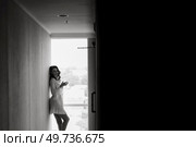 brown-haired girl in the morning in a bathrobe in the hotel corridor with a glass of white wine. Стоковое фото, агентство Ingram Publishing / Фотобанк Лори