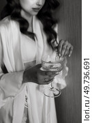 brown-haired girl in the morning in a bathrobe in the hotel corridor with a glass of white wine. Стоковое фото, агентство Ingram Publishing / Фотобанк Лори