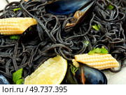 Vegan black bean pasta or linguine with boiled mussels. Spaghetti with seafood. Pasta vongole. Close up.. Black pasta with mussels and corn. Стоковое фото, агентство Ingram Publishing / Фотобанк Лори