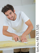 a male worker plasterer cutting a foam. Стоковое фото, агентство Ingram Publishing / Фотобанк Лори