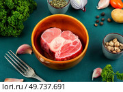 Uncooked raw piece red meat and vegetables on the kitchen table. Set of ingredients for soup or borscht.. Raw beef bones for soup. Стоковое фото, агентство Ingram Publishing / Фотобанк Лори