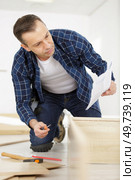 professional furniture assembly worker assembles shelf. Стоковое фото, агентство Ingram Publishing / Фотобанк Лори