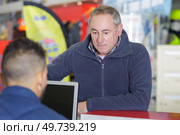 salesman and client at cash counter in hardware store. Стоковое фото, агентство Ingram Publishing / Фотобанк Лори