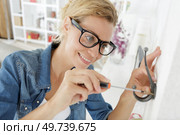 woman mounting coat hook in the home. Стоковое фото, агентство Ingram Publishing / Фотобанк Лори
