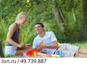 young couple lounging in sunny spring day at picnic outdoors. Стоковое фото, агентство Ingram Publishing / Фотобанк Лори