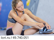 sportswoman putting on footwear for climbing. Стоковое фото, агентство Ingram Publishing / Фотобанк Лори