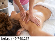 High angle of crop anonymous massage therapist rubbing back of female patient lying on couch during physiotherapy treatment. Masseuse doing massage to woman in salon. Стоковое фото, агентство Ingram Publishing / Фотобанк Лори