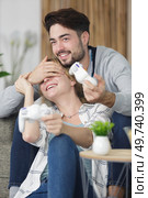 man covering girlfriends eyes during game of playstation. Стоковое фото, агентство Ingram Publishing / Фотобанк Лори
