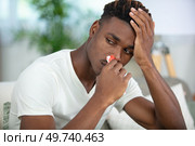 young man with tissue in his nostril has nose bleed. Стоковое фото, агентство Ingram Publishing / Фотобанк Лори