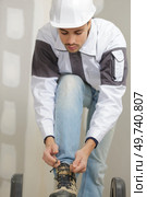 a worker tying shoe laces. Стоковое фото, агентство Ingram Publishing / Фотобанк Лори