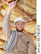young builder installing electrical cable trunking. Стоковое фото, агентство Ingram Publishing / Фотобанк Лори
