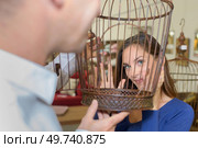 View of woman's face through birdcage. Стоковое фото, агентство Ingram Publishing / Фотобанк Лори